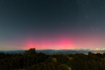Night landscape featuring pink northern lights over the Montsec Range (Lleida, Spain)