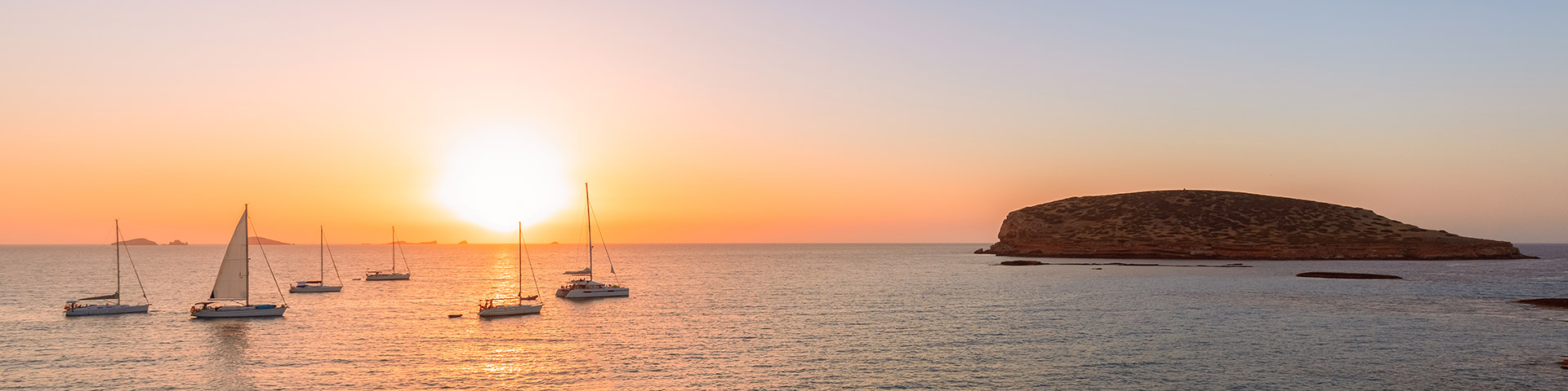 Veleros en Cala Comte (Cala Conta), contemplando la puesta de sol en la isla de Ibiza