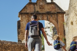 Una familia recorre las calles históricas de Ronda camino del Arco de Felipe V, uno de los rincones monumentales de la ciudad malagueña.