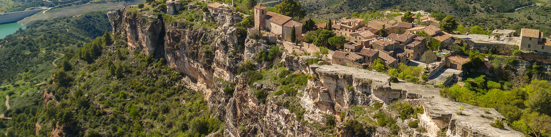 Vista aérea del pueblo de Siurana encaramado en lo alto de una escarpa en las Montañas de Prades, con vistas al embalse de Siurana