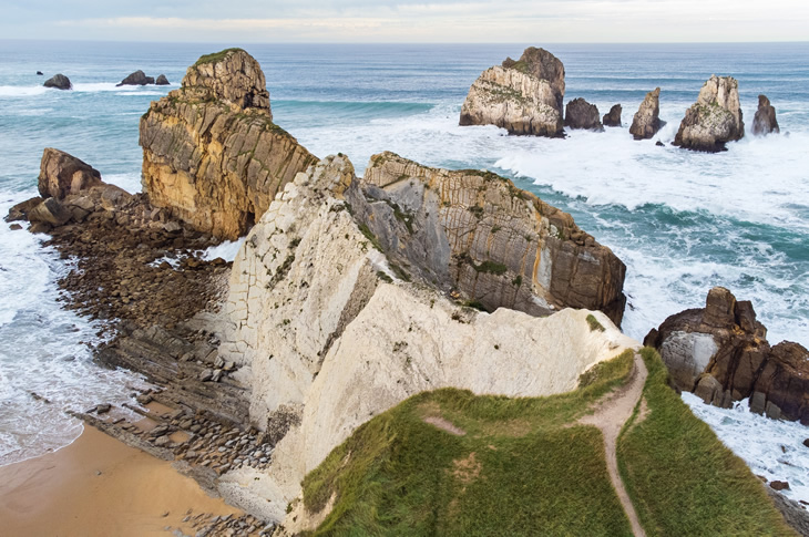 Aerial view of the rock formations and cliffs along Portio Beach (Costa Quebrada Geopark) Aerial view of the rock formations and cliffs along Portio Beach (Costa Quebrada Geopark)