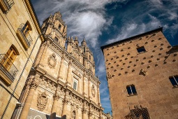 : Facade of the Church of La Clerecía and the famous Casa de las Conchas in Salamanca