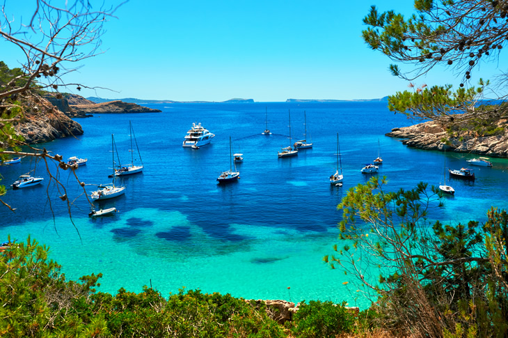 Luksusbådudflugter er blandt de mest populære aktiviteter for besøgende på De Baleariske Øer. På billedet ligger sejlbåde og yachter fortøjet ved Cala Salada (Ibiza, Spanien) Luksusbådudflugter er blandt de mest populære aktiviteter for besøgende på De Baleariske Øer. På billedet ligger sejlbåde og yachter fortøjet ved Cala Salada (Ibiza, Spanien)