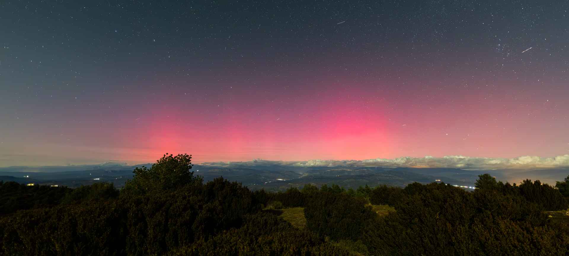Paysage nocturne avec des aurores boréales rosées dans la Sierra del Montsec (Lleida, Espagne)
