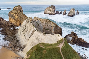 Vista aérea das formações rochosas e falésias ao longo da praia de Portio (Costa Quebrada Geopark) © Shutterstock