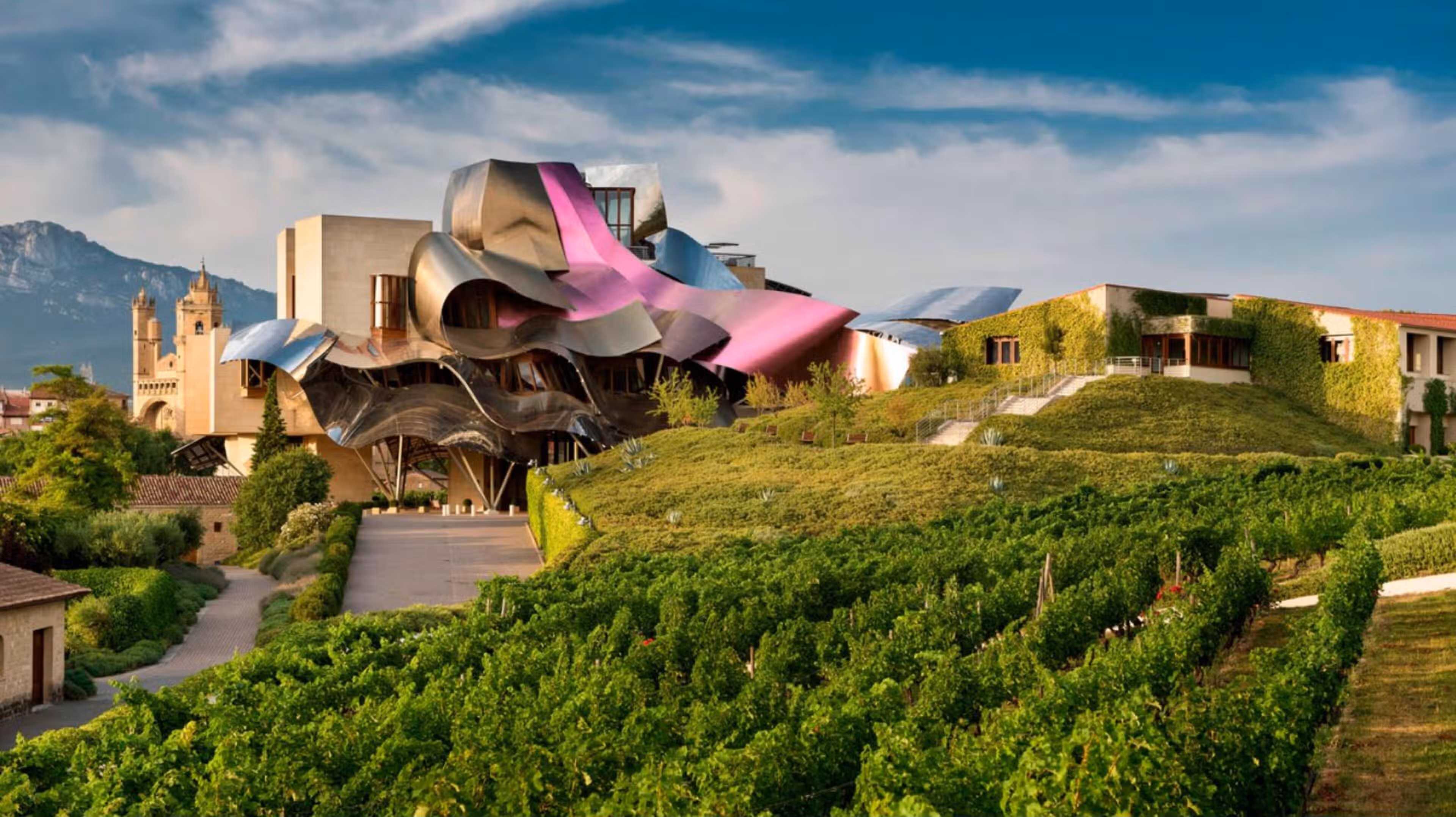 Localizado na Cidade do Vinho do Marquês de Riscal, este hotel 5 estrelas em Elciego (Rioja Alavesa) é um chateaux do século XXI projetado pelo arquiteto Frank Gehry © Marriott International Localizado na Cidade do Vinho do Marquês de Riscal, este hotel 5 estrelas em Elciego (Rioja Alavesa) é um chateaux do século XXI projetado pelo arquiteto Frank Gehry © Marriott International