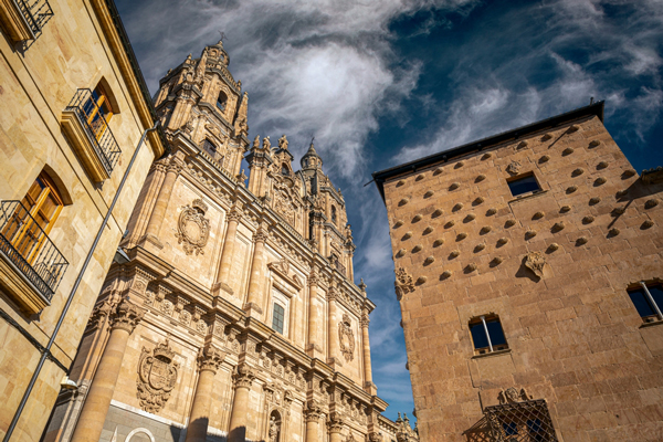 Fassade der Kirche von La Clerecía und die berühmte Casa de las Conchas in Salamanca Fassade der Kirche von La Clerecía und die berühmte Casa de las Conchas in Salamanca