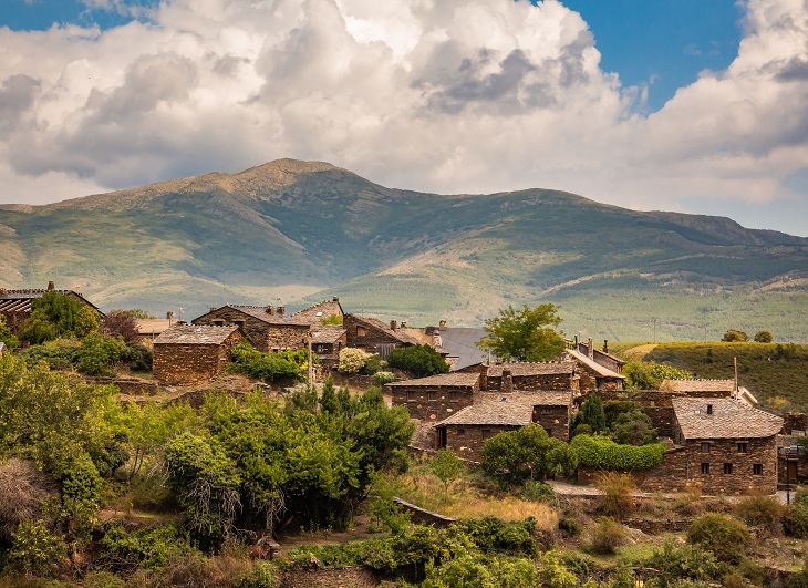 Die Häuser von Roblelacasa fügen sich in die Hügellandschaft mit Zistrosen in der Sierra de Ayllón ein